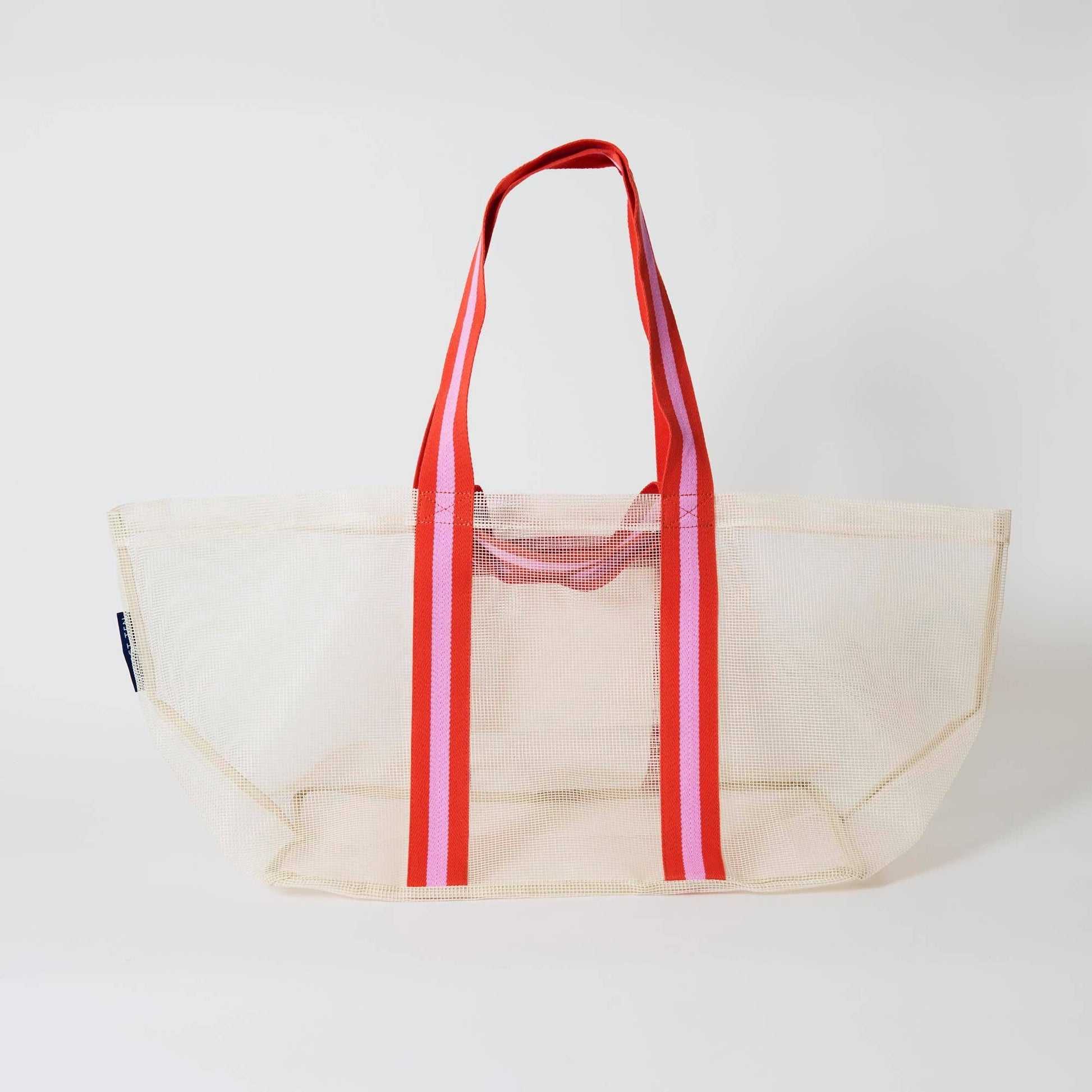 Beige tote bag with red and pink striped handles on a white background